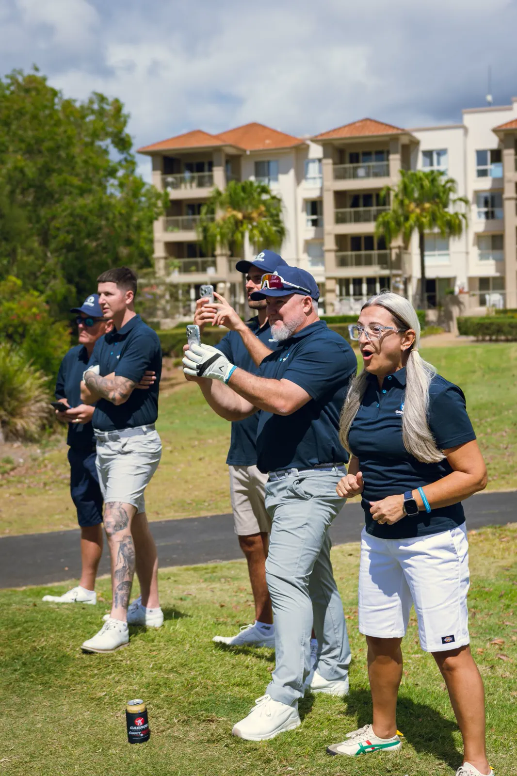 Carroll Group players cheering and filming a shot from beside the fairway